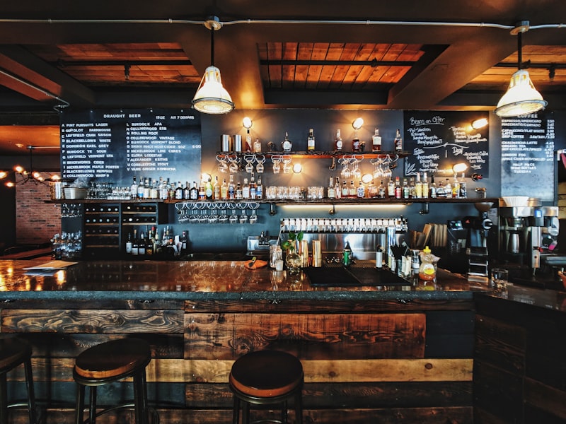 Balcão de bar com garrafas e luminárias suspensas